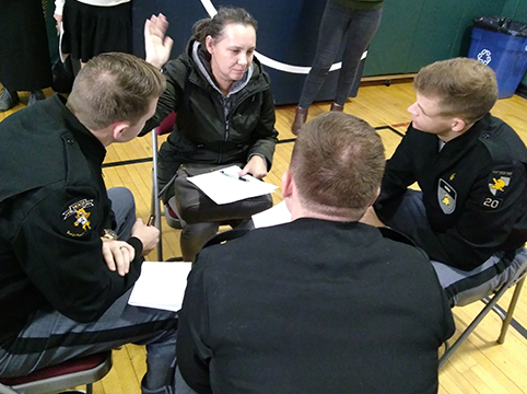 Volunteers helping a student practicing taking the oath of allegiance